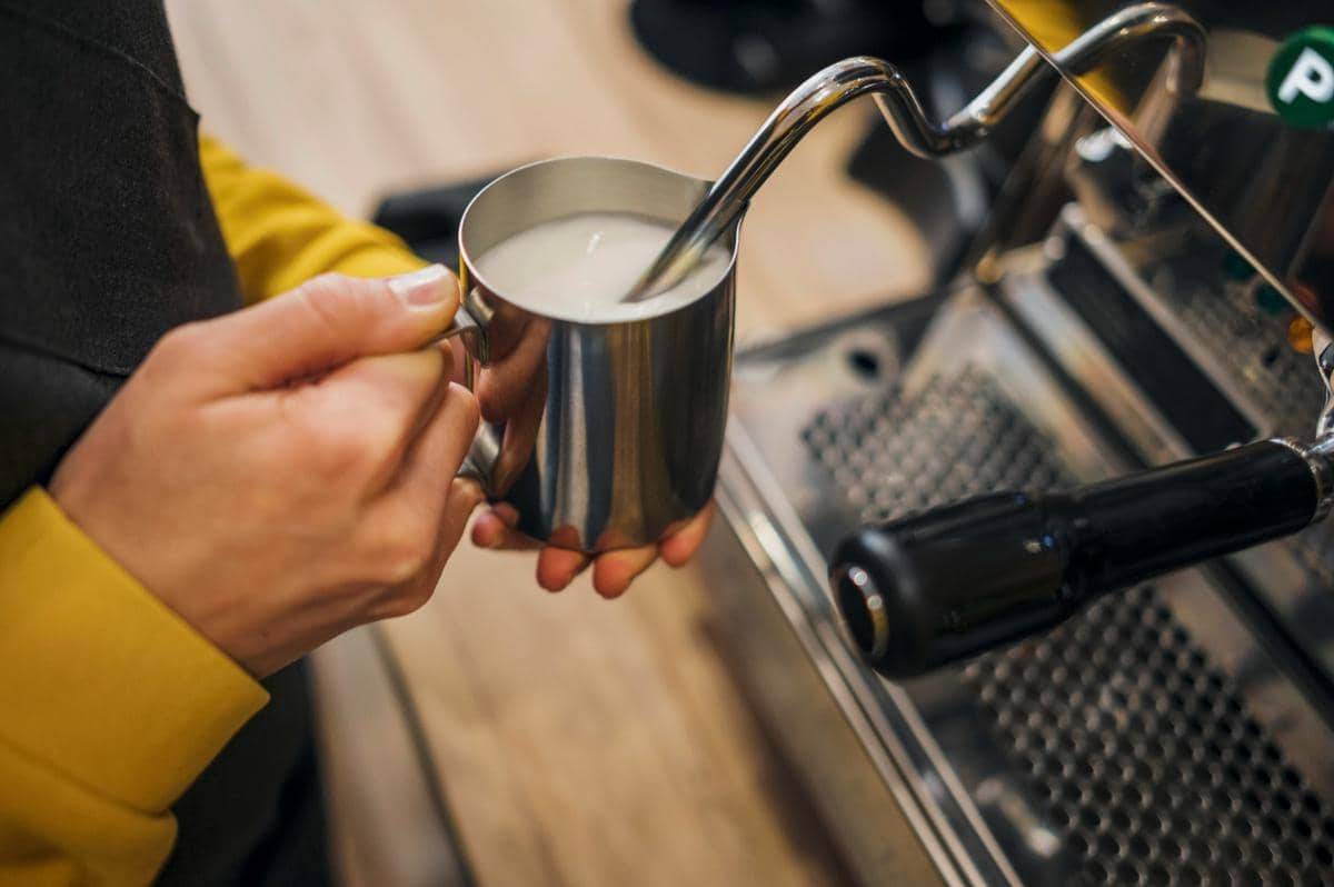 ilustrasi milk frothing pitcher dengan steam wand