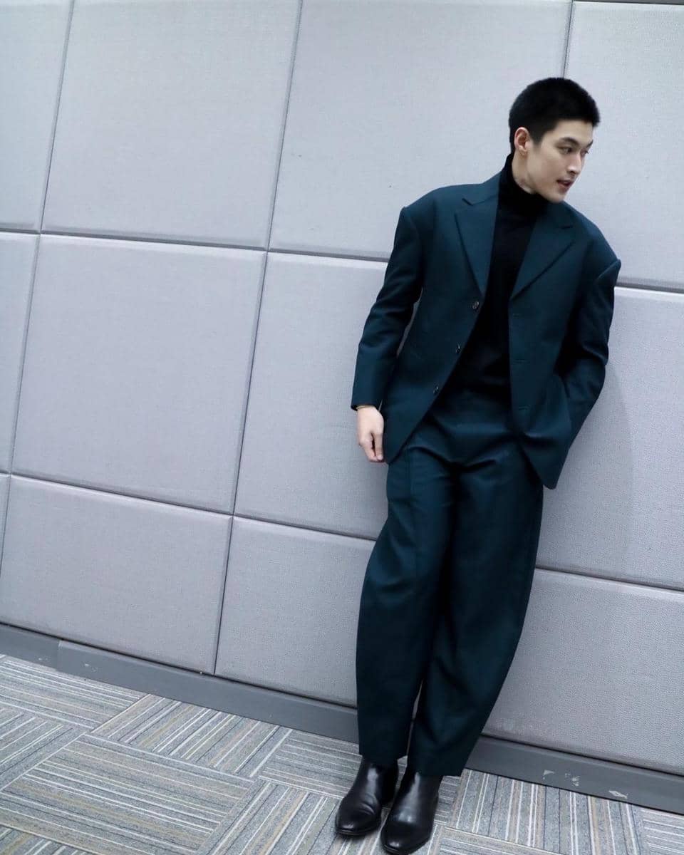 Krating Khunnarong bergaya dengan setelan jas sebagai inspirasi OOTD pria yang tampil rapi dan berkelas.