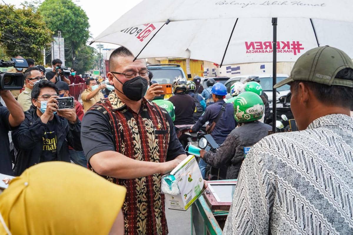 Anggota Komisi C DPRD DKI Jakarta, Hardiyanto Kenneth membagikan masker gratis di Jalan Latumenten, Jakarta Barat.