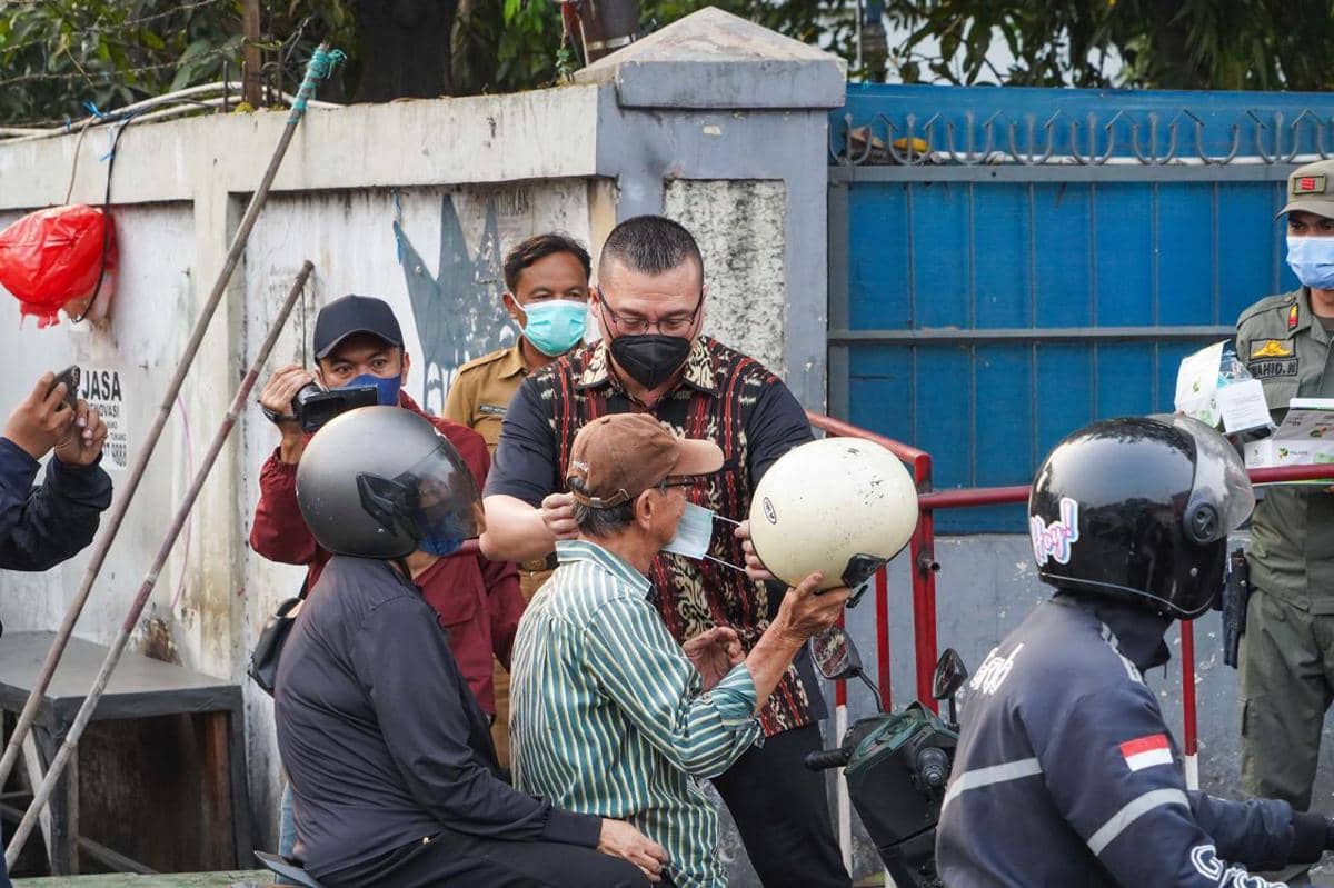 Anggota Komisi C DPRD DKI Jakarta, Hardiyanto Kenneth membagikan masker gratis di Jalan Latumenten, Jakarta Barat.