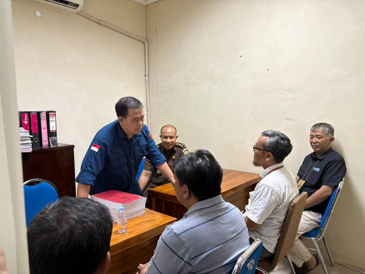 Dua tersangka kasus penggelapan pajak berdiri di dalam ruangan setelah ditangkap Kanwil DJP Jawa Timur III.