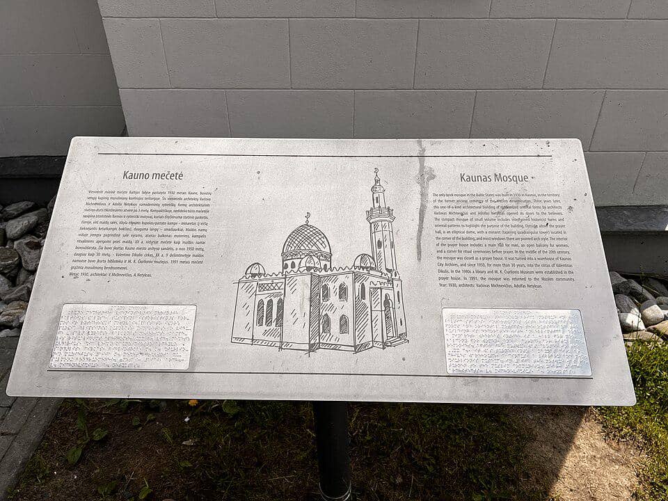 Plakat informasi berdiri di area depan Masjid Kaunas, berisi keterangan mengenai bangunan masjid tersebut.