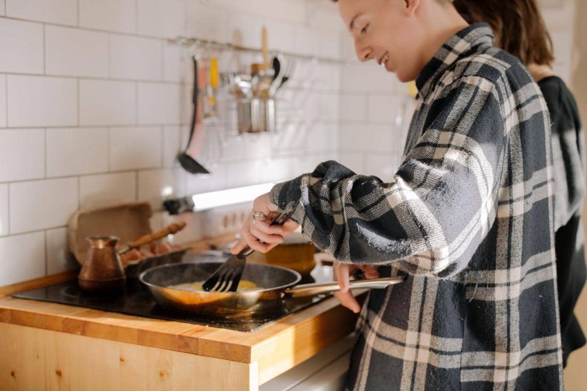 ilustrasi seorang pria memasak makanan dengan teflon