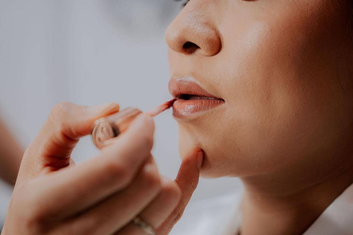 mengaplikasikan lip base dengan merata