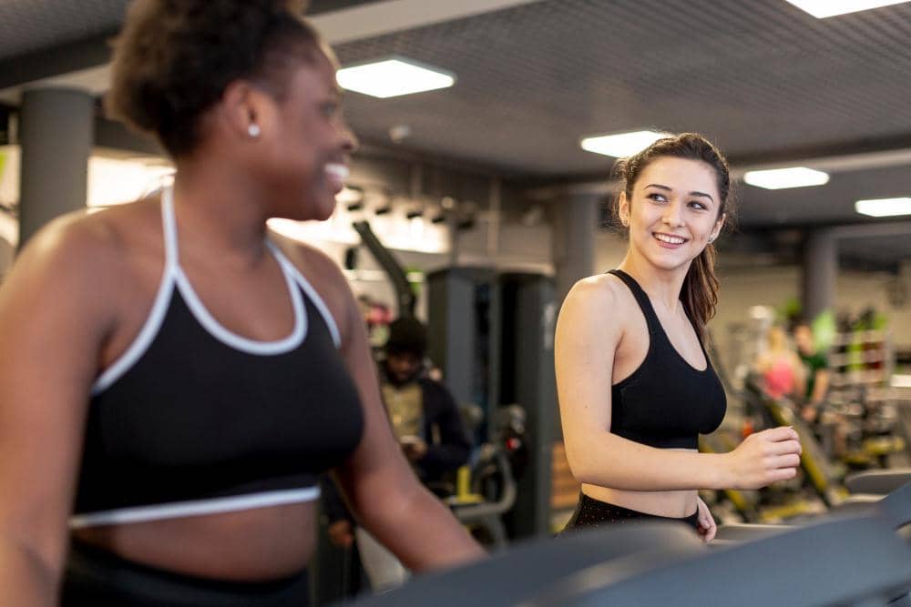 Ilustrasi perempuan berolahraga di gym, menggambarkan aktivitas kebugaran dengan suasana latihan di dalam ruangan.