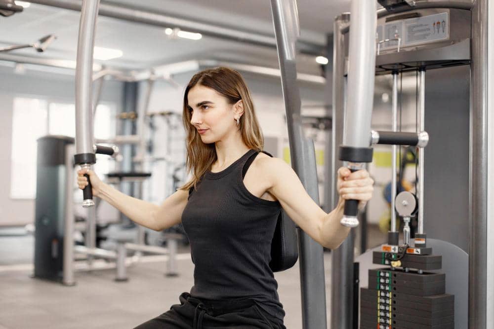 Ilustrasi perempuan berolahraga di gym dengan pakaian olahraga, menggambarkan aktivitas kebugaran dan latihan fisik.
