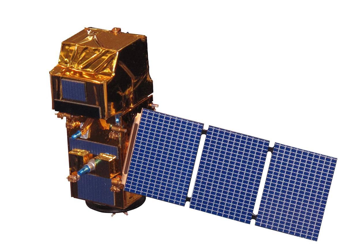 Ilustrasi Sentinel-1 dengan panel surya, berada di atas permukaan Bumi berlatar gelap ruang angkasa.