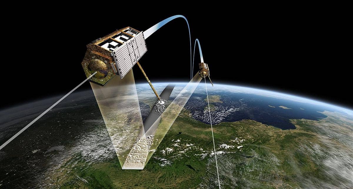Ilustrasi satelit TerraSAR-X dan TanDEM-X terbang dalam formasi di atas Bumi untuk misi pengamatan radar.