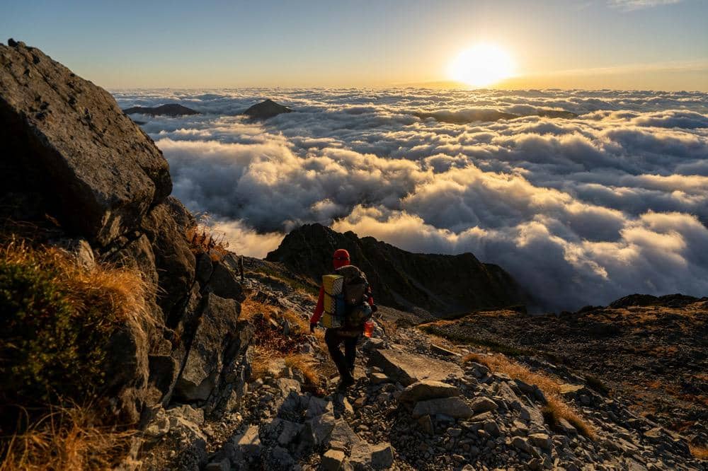 ilustrasi seorang pendaki trekking di gunung sendirian