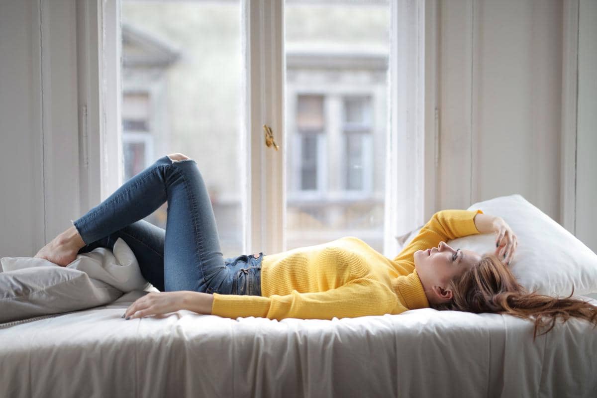 Perempuan berbaring di kamar