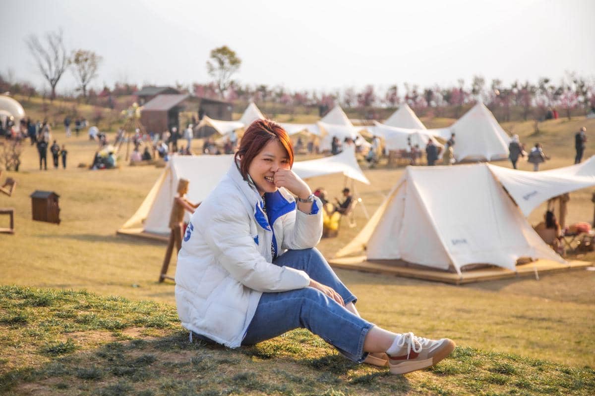 ilustrasi seorang wanita sedang berada di area camping ground