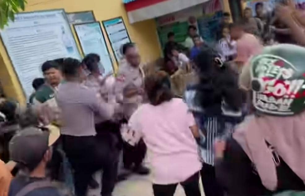 Sejumlah warga berkerumun di depan gedung sekolah saat polisi membawa guru terduga pelaku pencabulan di Alor.
