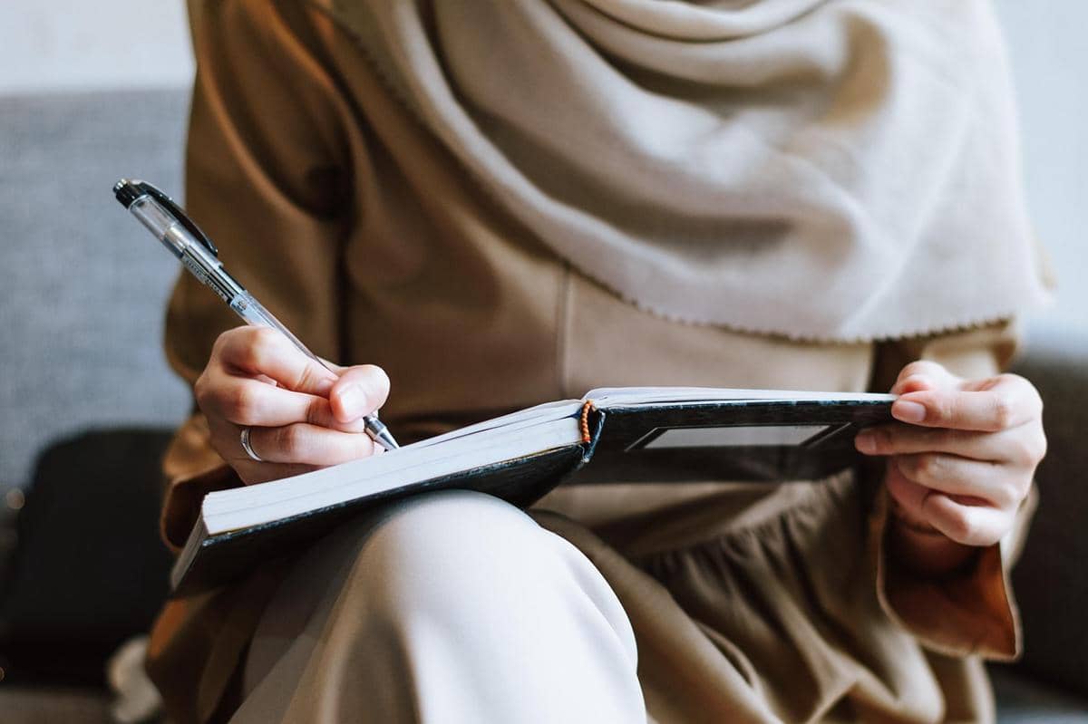 seorang wanita menulis di atas kertas 
