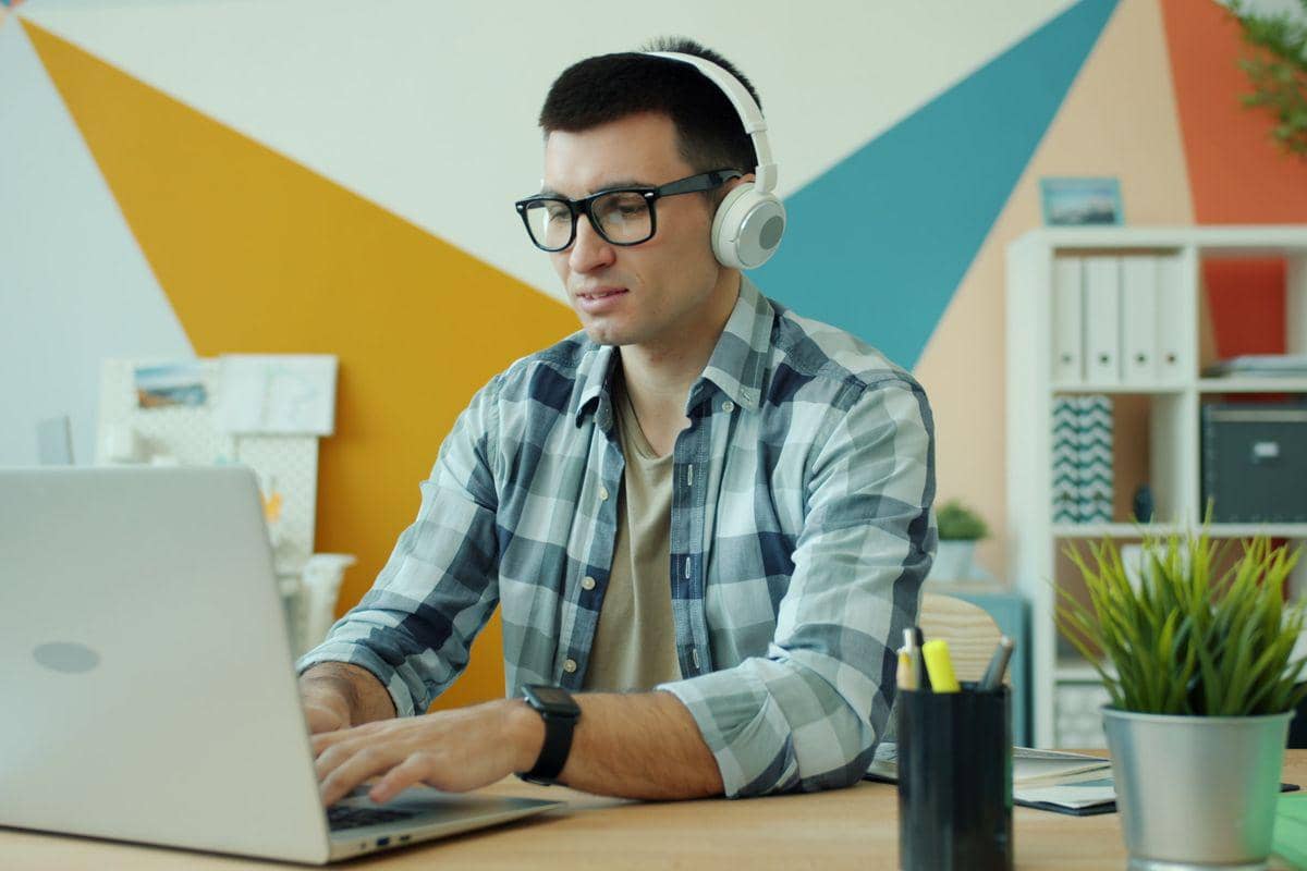 Ilustrasi seseorang mendengarkan playlist musik melalui headphone untuk membantu menjaga fokus saat bekerja.