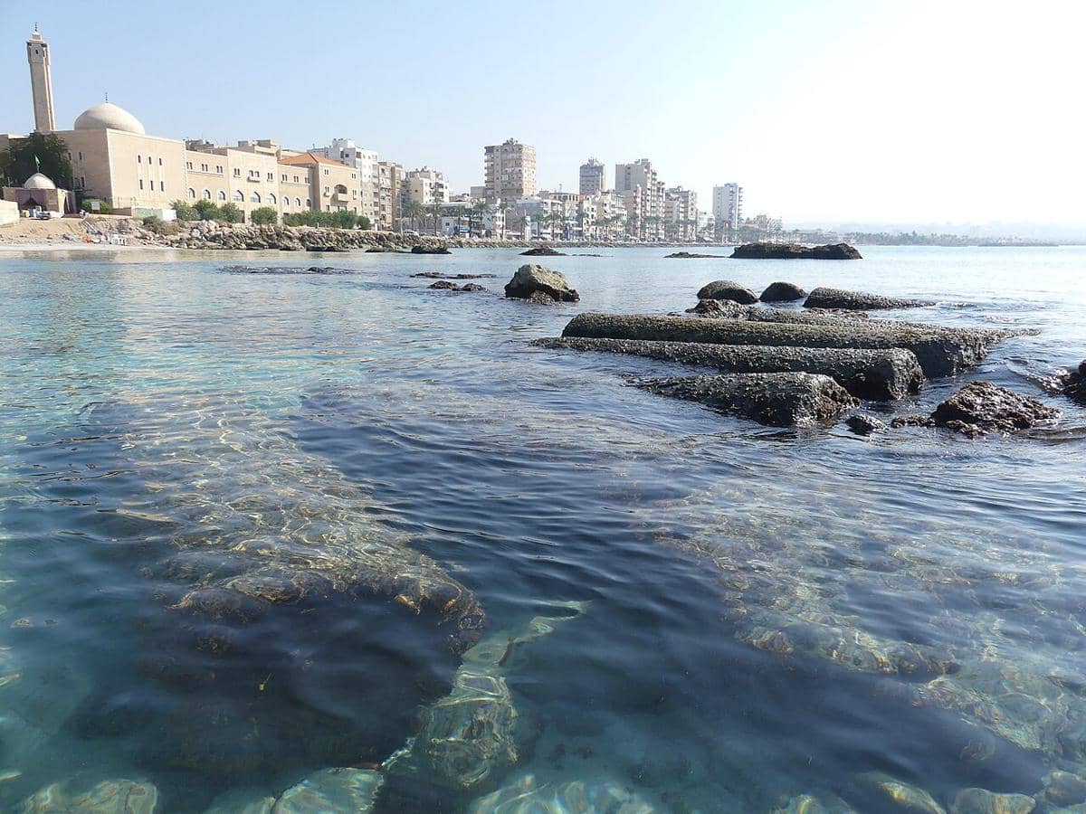 potret reruntuhan pilar-pilar kuno di lepas pantai yang merupakan bagian dari pelabuhan kuno bernama Egyptian Harbour di masa lalu dengan latar belakang lanskap Kota Tyre modern