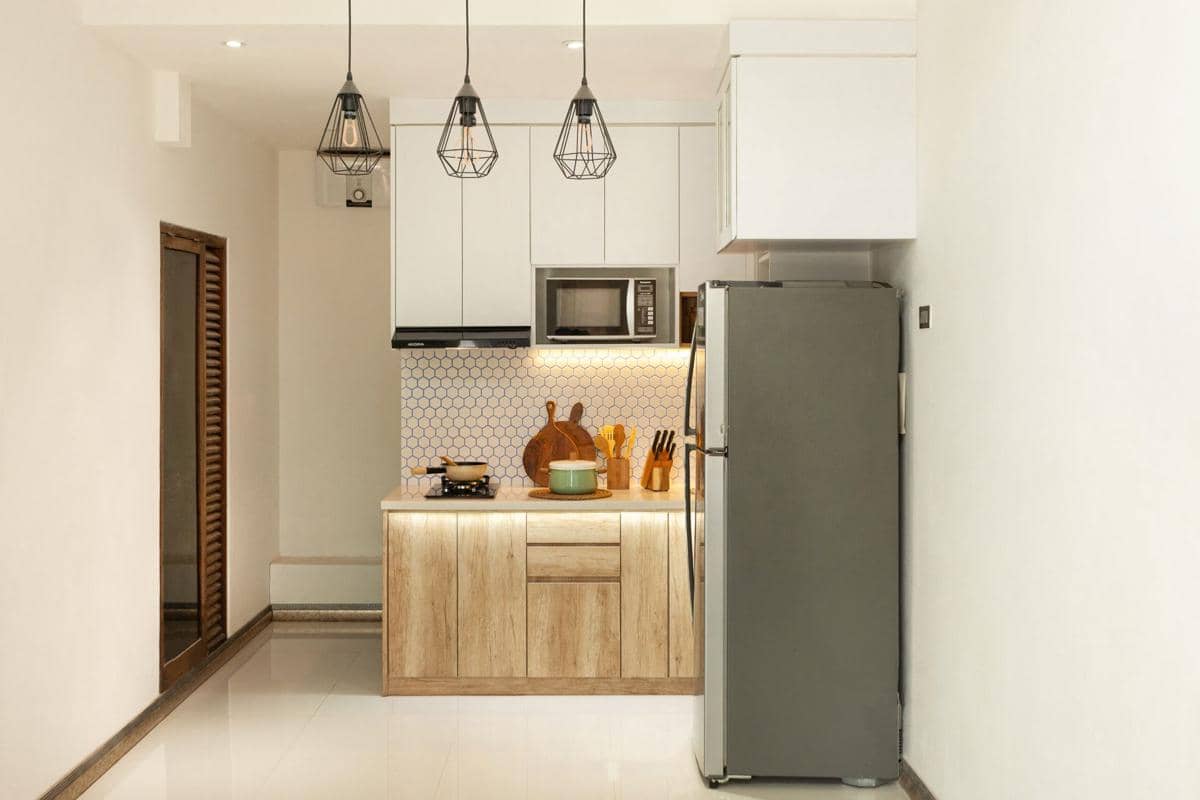 Kulkas dua pintu berwarna putih berdiri di dalam ruangan sebagai ilustrasi peralatan rumah tangga untuk menyimpan makanan.