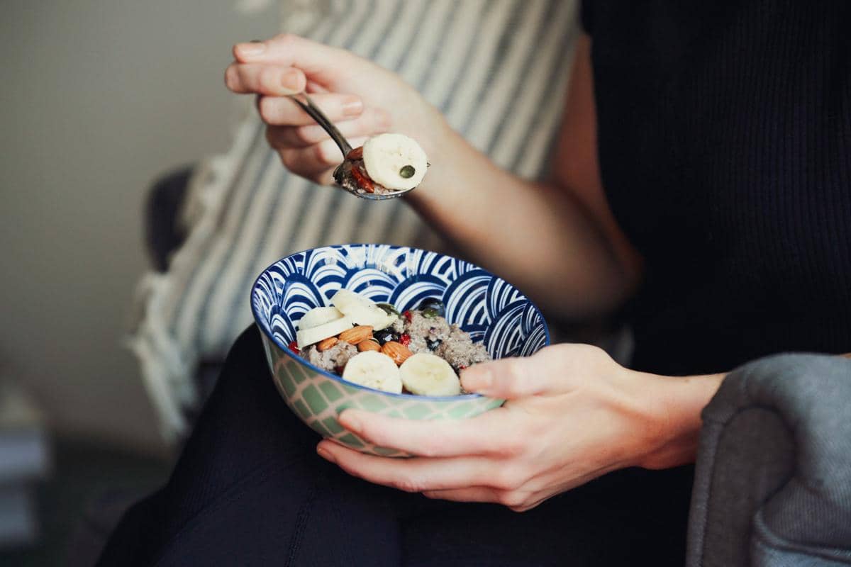 Semangkuk oatmeal berbahan whole grains disajikan sebagai sarapan sehat bersama aneka potongan buah segar.