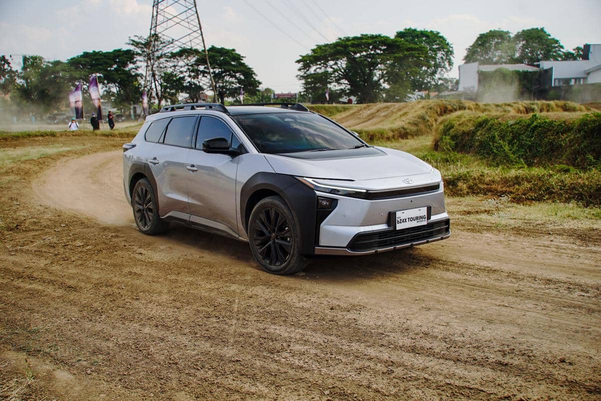 Toyota bZ4X Touring melaju di jalur off-road, memperlihatkan kemampuan SUV listrik pada medan tanah berbatu.