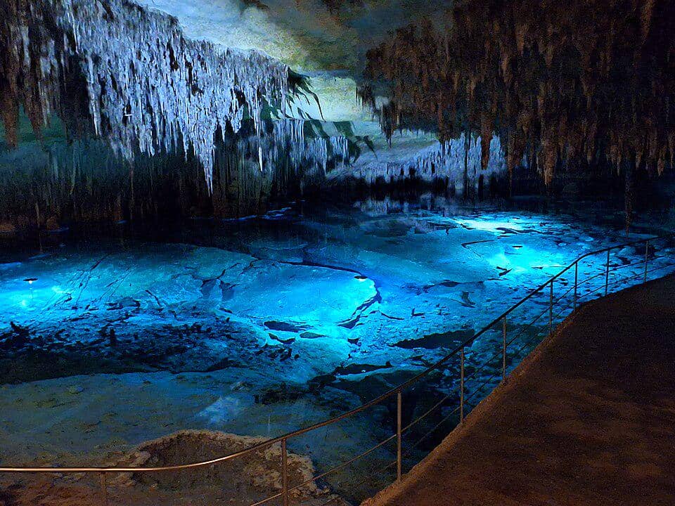 Danau Martel berair tenang di dalam Gua Drach, dikelilingi formasi stalaktit dan stalagmit di Mallorca.