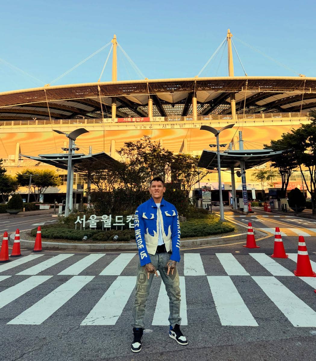Ganindra Bimo mengenakan kaus Persib dan berpose di Seoul, Korea Selatan, sebagai bentuk dukungan untuk klub tersebut.