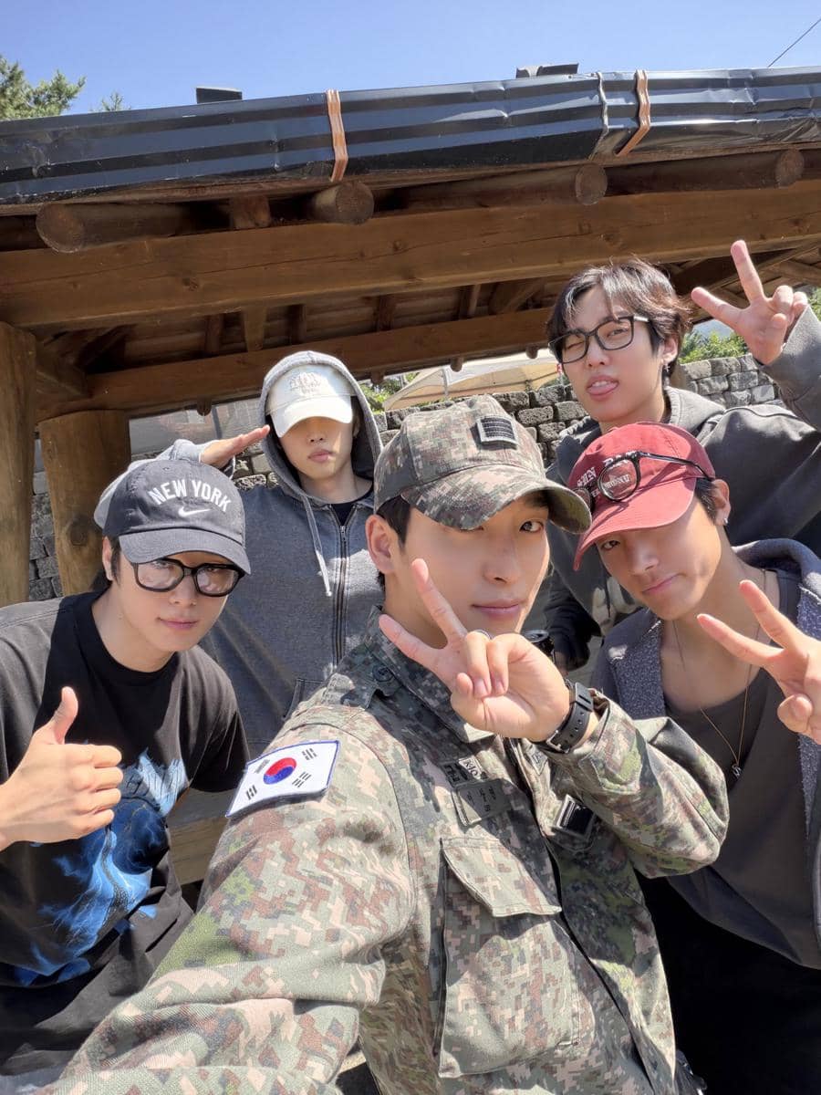 Sangyeon THE BOYZ tersenyum dalam potret mengenakan seragam militer usai menyelesaikan masa wajib militer.