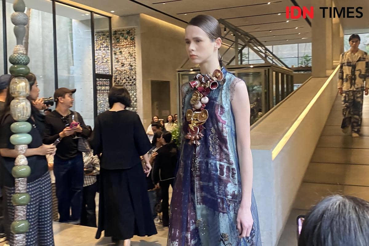 Model berjalan di runway dengan busana hasil kolaborasi BIYAN dan GAYA CERAMIC dalam peragaan mode.