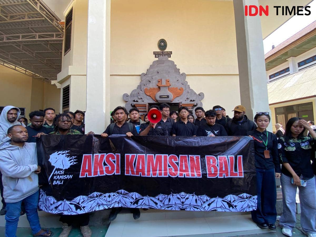 Sejumlah peserta Aksi Kamisan Bali bersama Tomy Priatna Wiria berdiri di depan Ruang Sidang Kartika, PN Denpasar.