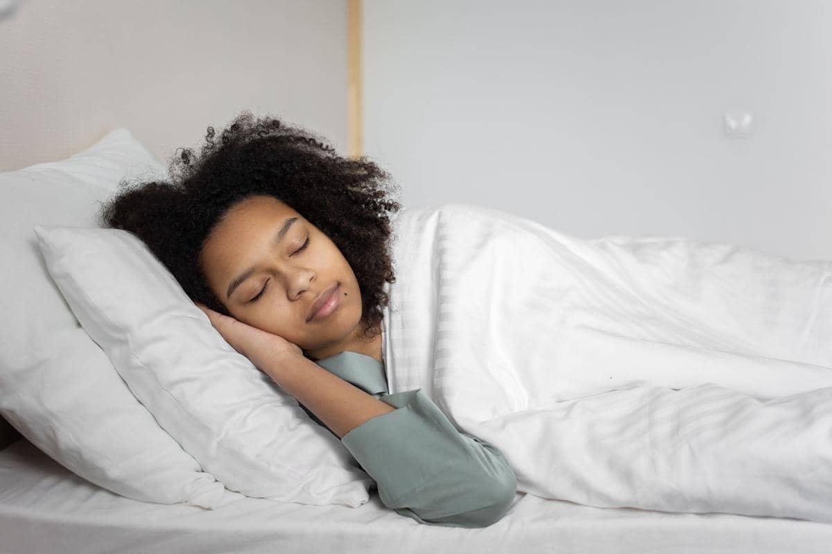 Ilustrasi wanita yang sedang tidur nyenyak dan memulihkan energi di kamar yang nyaman.