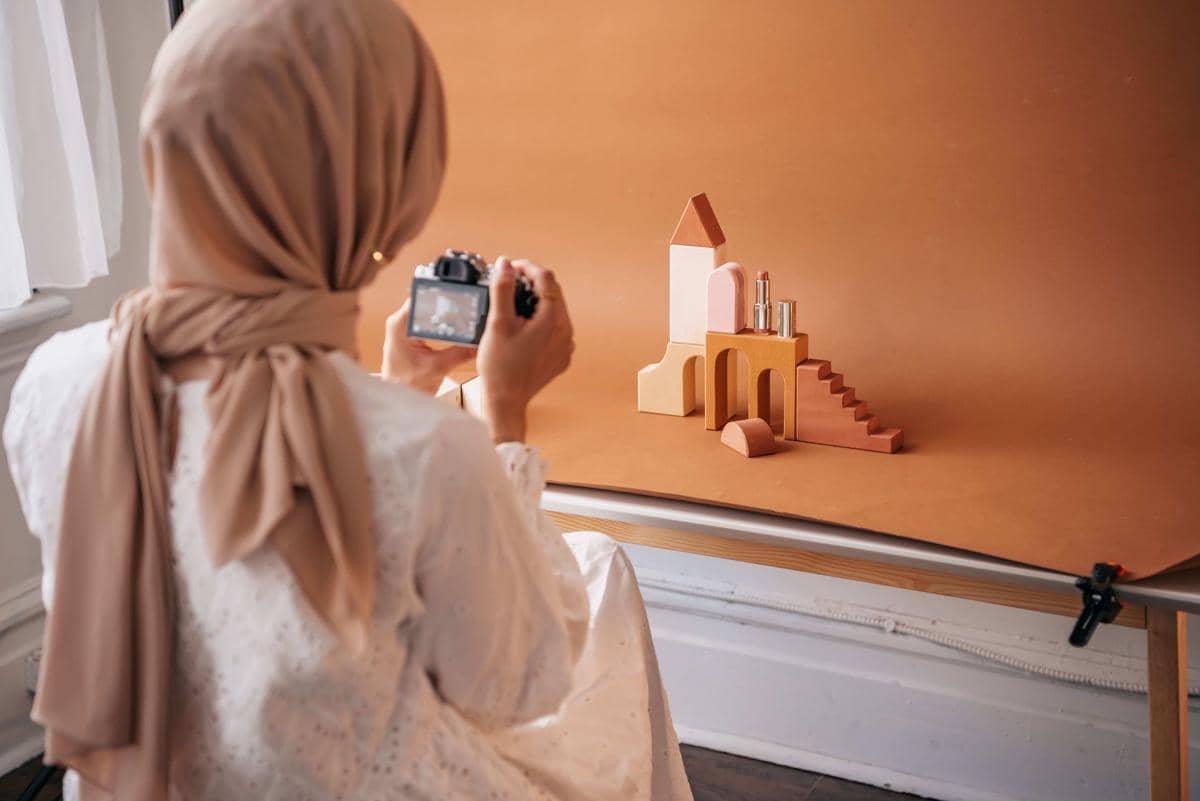 Seorang fotografer memegang kamera dan bersiap mengambil gambar dalam ilustrasi bertema fotografi dari Pexels.