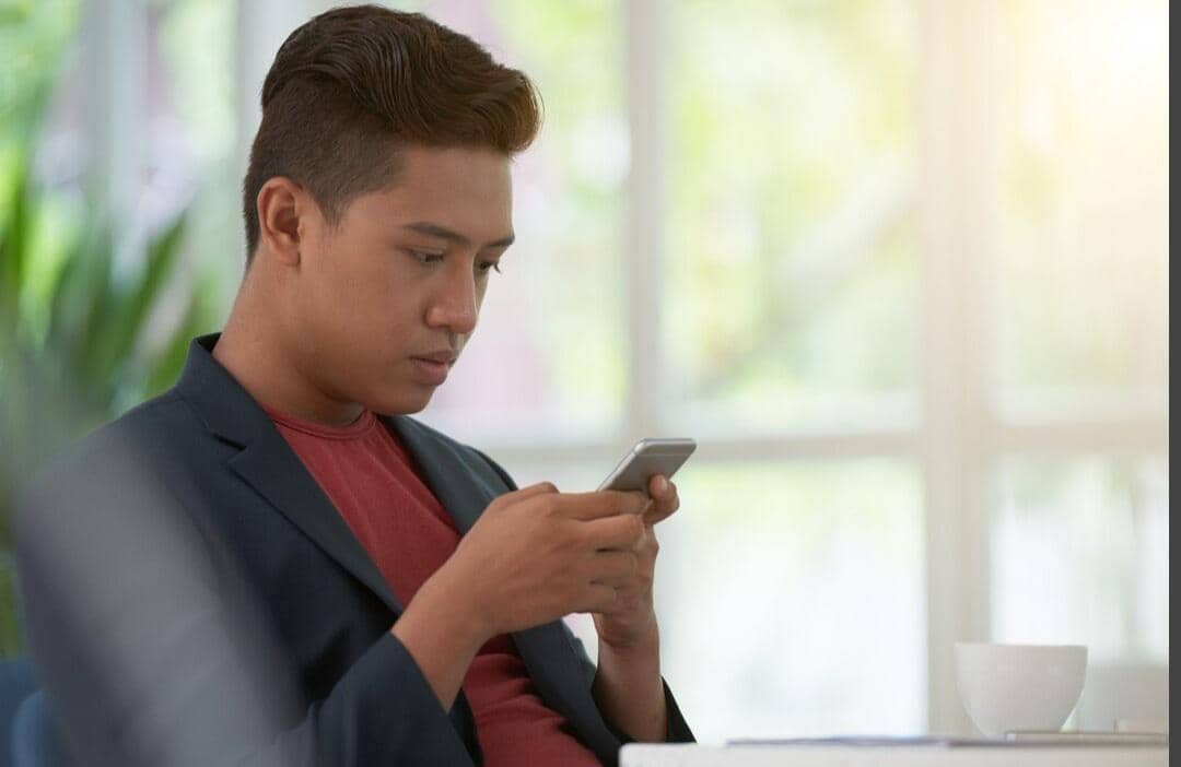 ilustrasi pria memandang foto mantan di hp (magnific.com/pressfoto)
