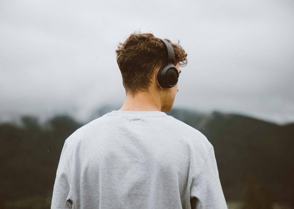 seorang pria menggunakan headphone di public area