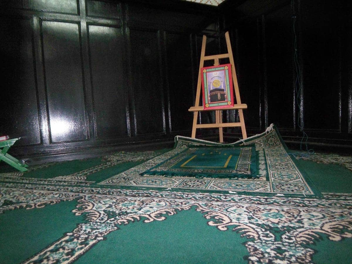 Area imam berdampingan dengan barisan makmum di dalam Masjid Cut Meutia, memperlihatkan tata ruang ibadah.