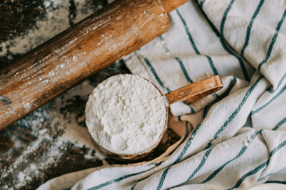 Bahan pastry berupa tepung, mentega, dan telur tersusun di meja untuk membuat kue cakar beruang rumahan.