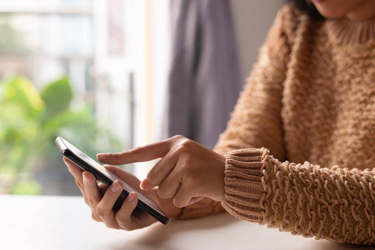 Close-up gadis memakai sweter melihat informasi online