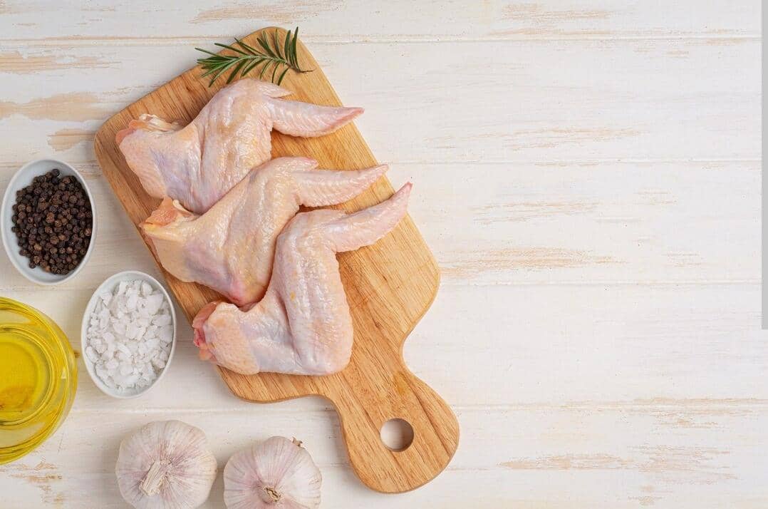 Ilustrasi seporsi sayap ayam goreng berwarna kecokelatan yang disajikan sebagai hidangan makanan utama.