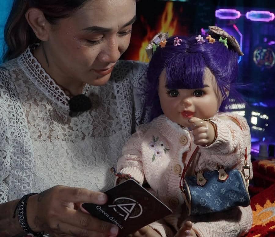 Queen Athena sedang menggunakan kartu oracle spirit bersama boneka arwah asuhannya.