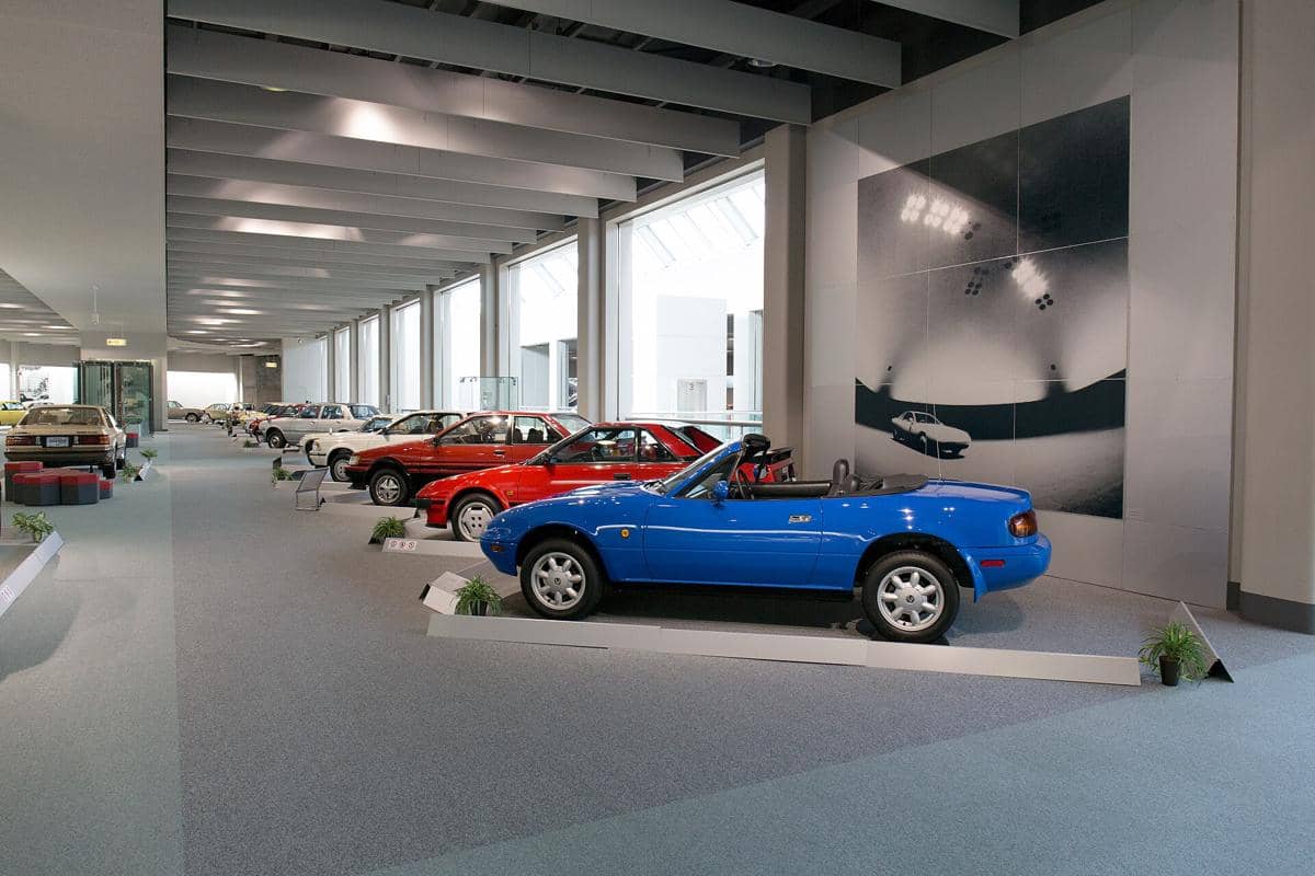 Tampak luar Toyota Automobile Museum dengan bangunan modern dan area lanskap di sekelilingnya pada siang hari.