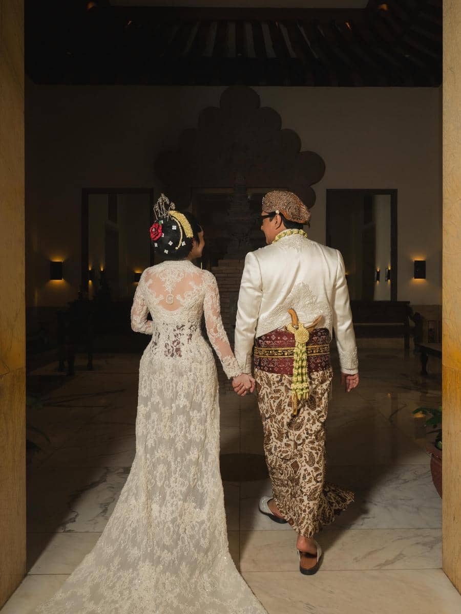 Andre Taulany dan Amanda Rigby berpose dalam potret pernikahan mengenakan busana pengantin bernuansa formal.