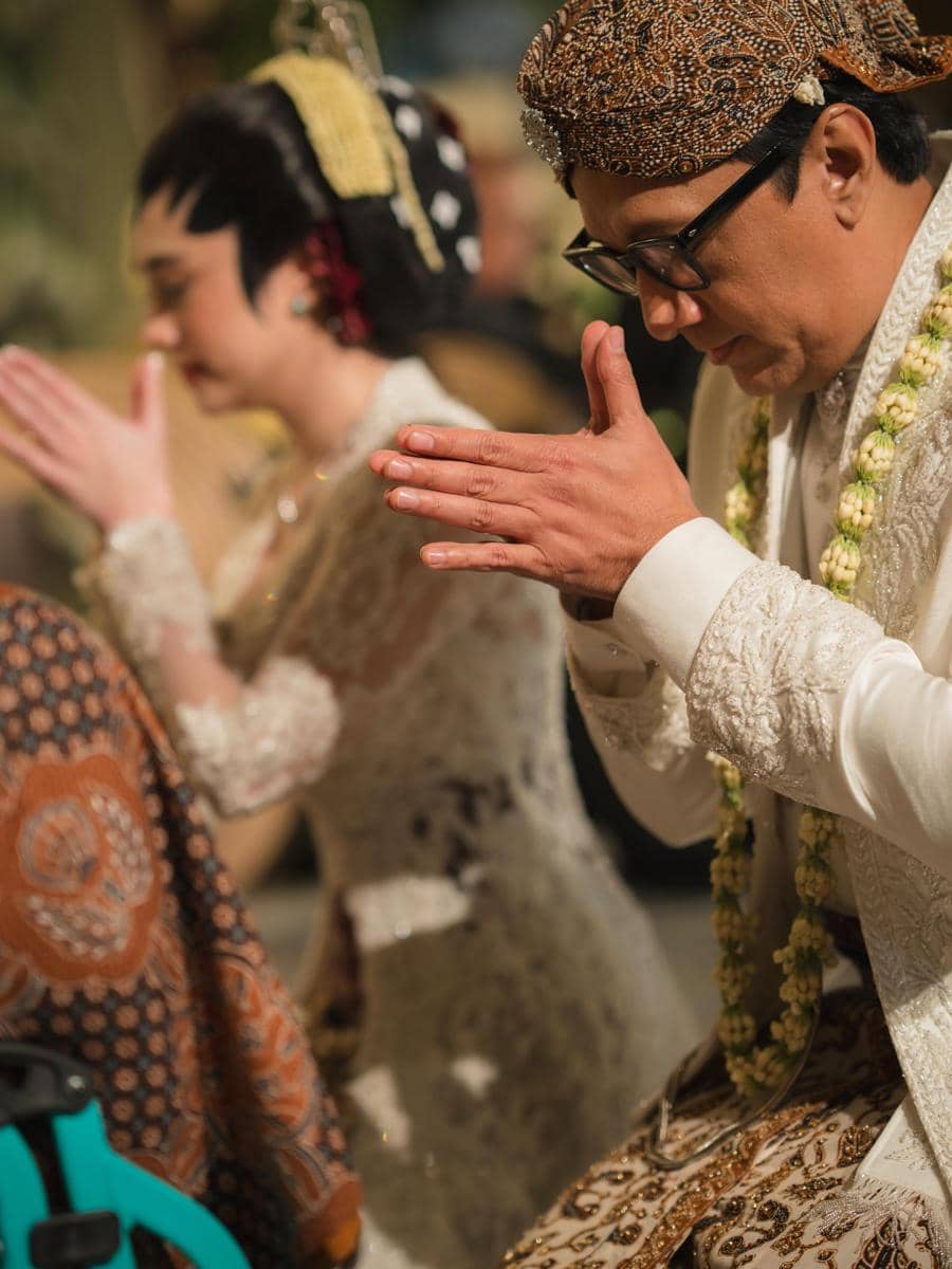 Andre Taulany dan Amanda Rigby berpose dalam potret bertema pernikahan dengan mengenakan busana pengantin.