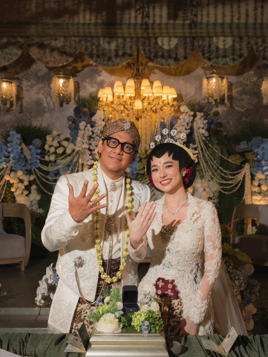 Andre Taulany dan Amanda Rigby berpose dalam potret pernikahan mengenakan busana pengantin di unggahan Instagram.
