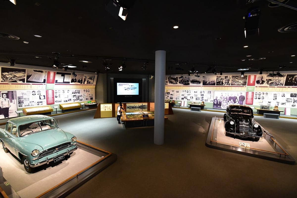 Tampak eksterior Toyota Kuragaike Commemorative Hall, bangunan berdinding putih dengan taman hijau di depannya.