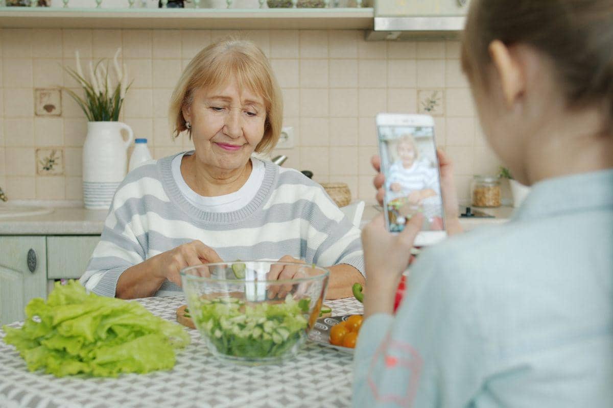 Ilustrasi memasak bersama orang tua lansia di dapur sambil menyiapkan makanan dalam suasana hangat.