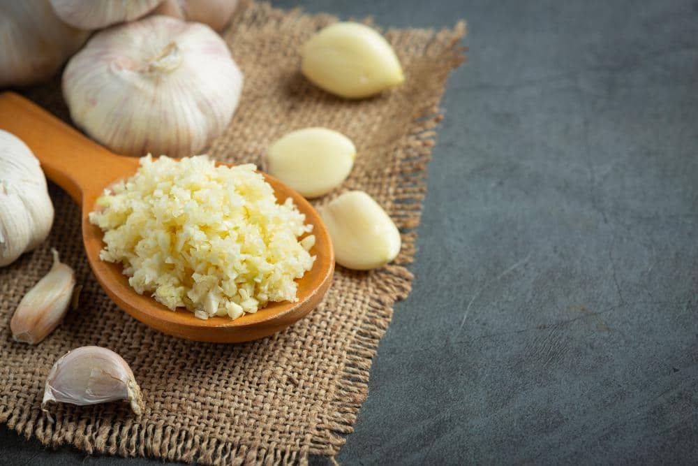 Ilustrasi bawang putih halus dengan tekstur lembut berwarna putih kekuningan sebagai bumbu masakan sehari-hari.