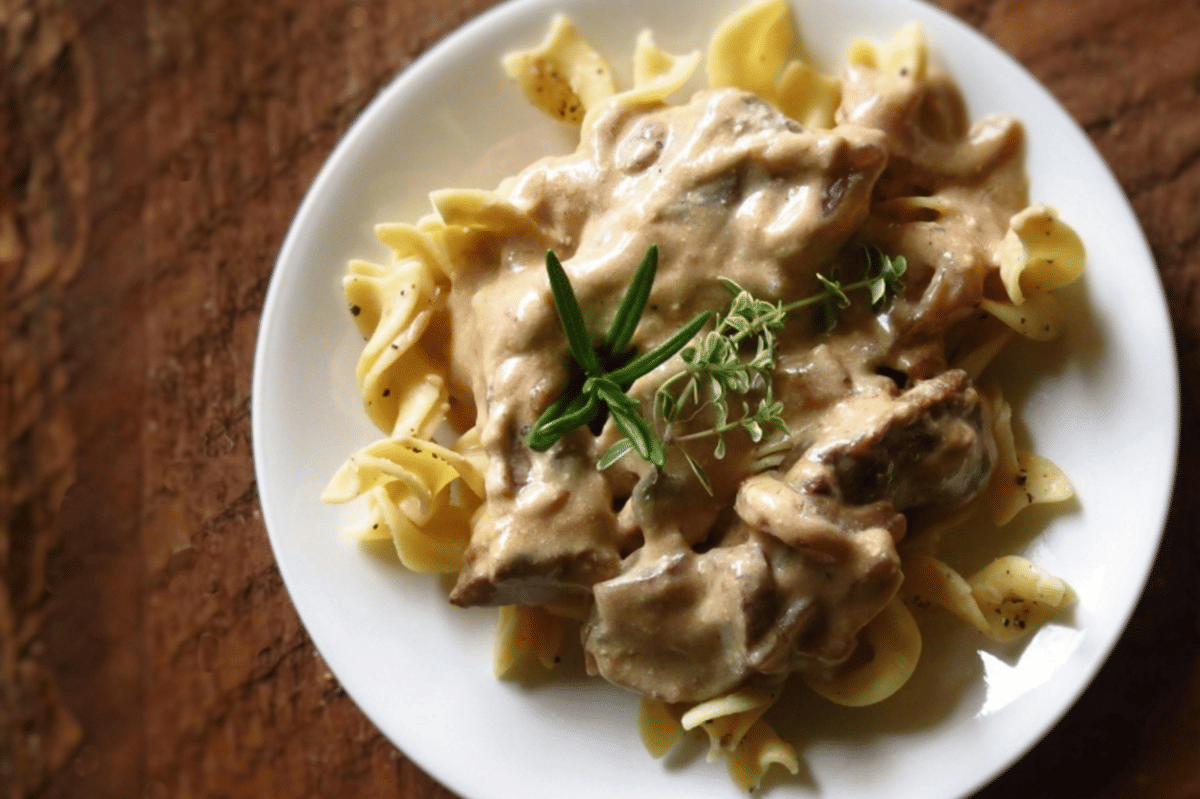 Ilustrasi hidangan ayam dengan saus gravy yang dimasak menggunakan slow cooker dan disajikan hangat.