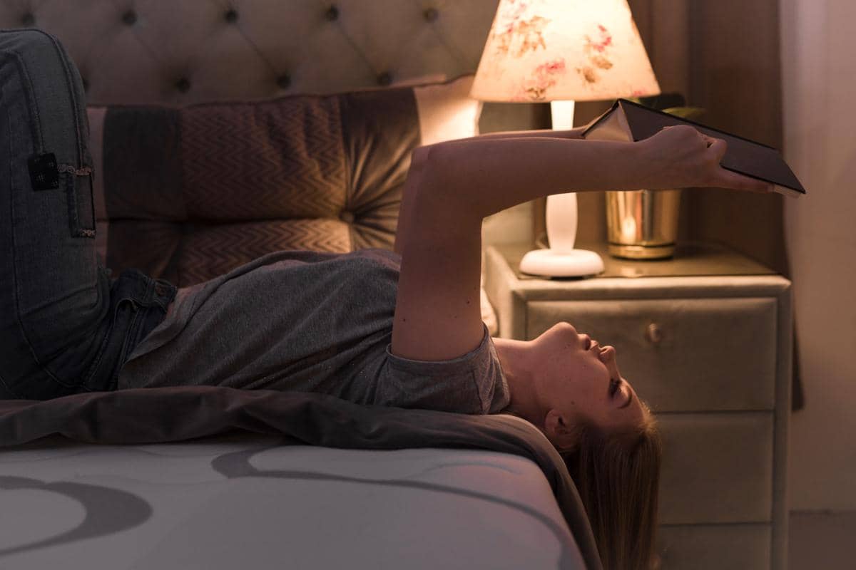 Wanita pirang berbaring telentang di tempat tidur