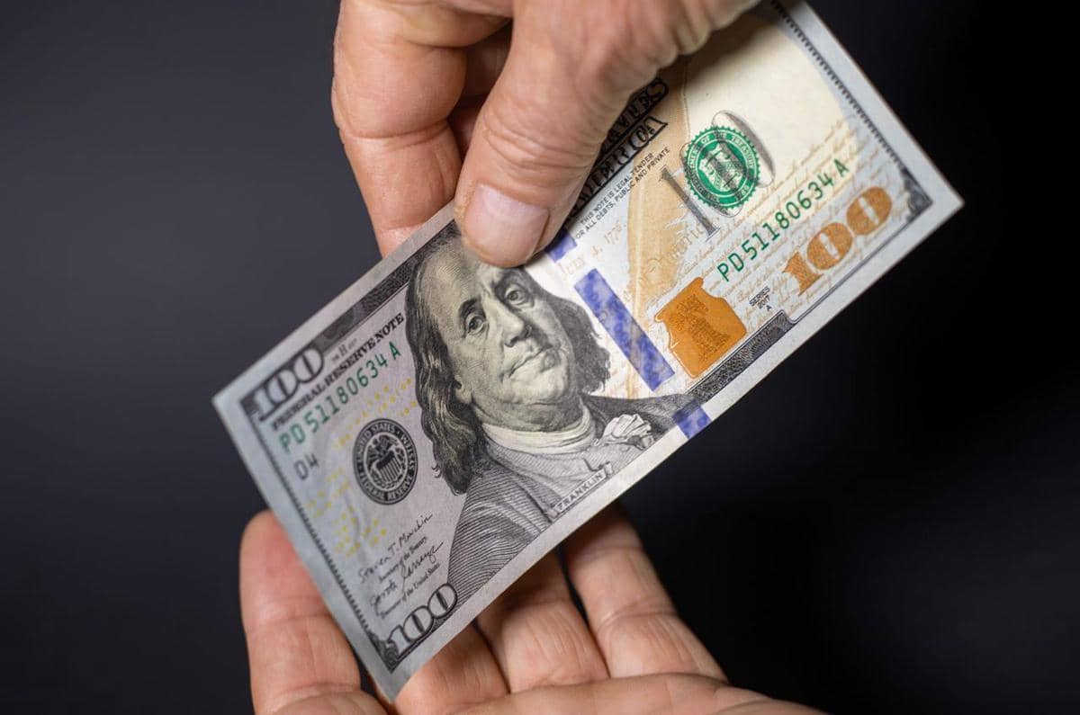 ilustrasi dua orang yang saling bertukar uang kertas seratus dolar yang masih baru