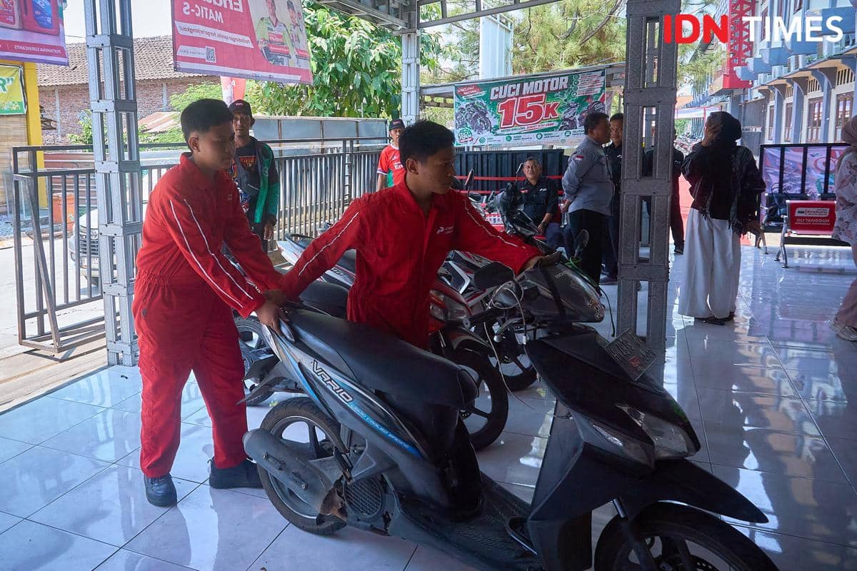 Dua siswa memindahkan sepeda motor di area Karya Speed, Rabu (16/9/2026). Aktivitas di bengkel menempatkan siswa dalam alur kerja yang tidak