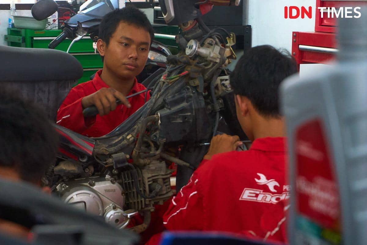 Seorang siswa menangani bagian mesin sepeda motor yang terbuka di Karya Speed, Rabu (16/9/2026). Dalam program EHS, siswa SMK memperoleh pel
