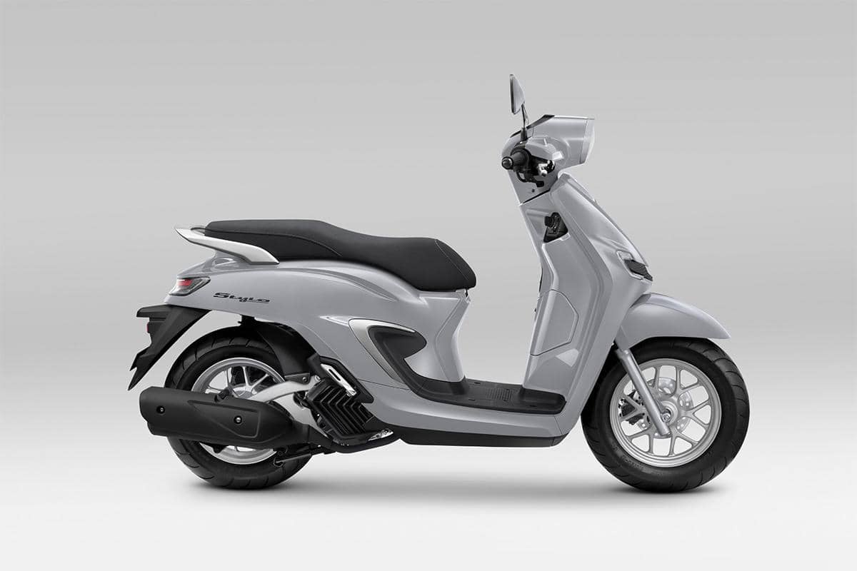 Honda Stylo Glam Grey berwarna abu-abu dengan bodi skuter bergaya klasik dan lampu depan bulat tampak dari sisi depan.