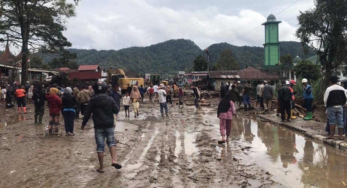 Warga melewati jalur lalu lintas yang terdampak bencana banjir bandang (Foto: IDN Times/Halbert Caniago)